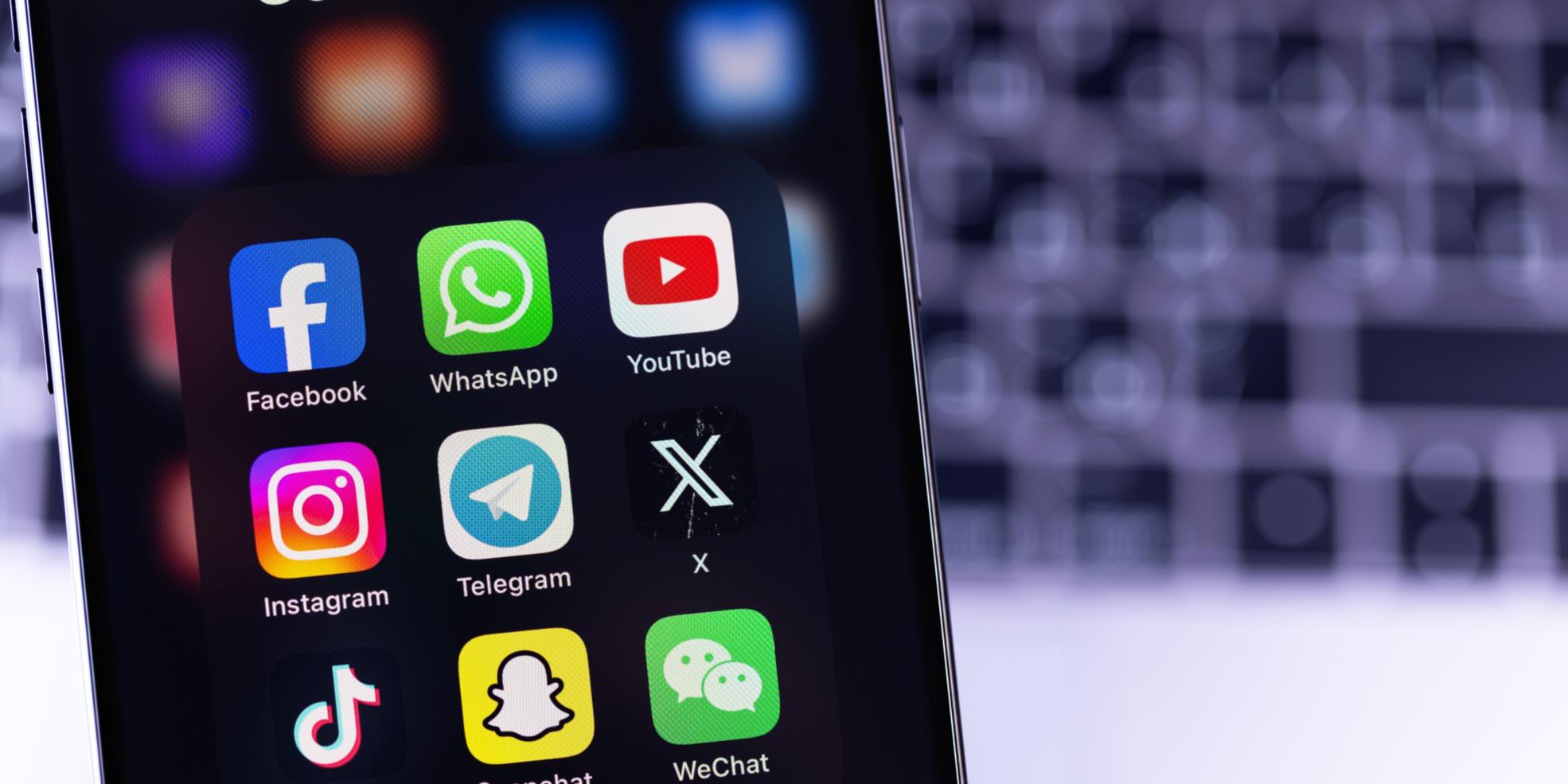 Bild von Handy mit Apps vor verschwommener Tastatur