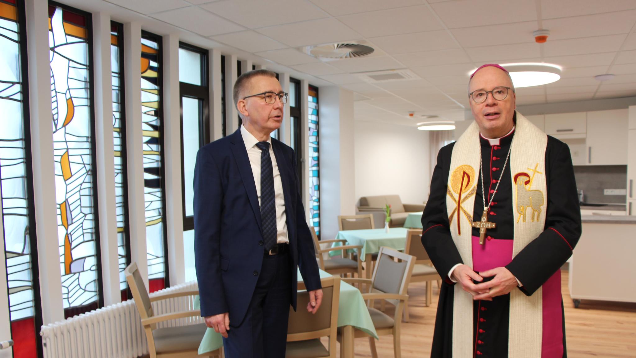 Michael Förster (links), Geschäftsführer der Gesellschaft der Katharinenschwestern und des Maria-Hilf-Krankenhauses Daun sowie Leiter der neuen Kurzzeitpflege-Einrichtung, beim Rundgang mit Bischof Dr. Stephan Ackermann - hier im ehemaligen Speisesaal des Konventhauses und zukünftigen Gemeinschaftsraum, in dem die Bleiverglasung der Fenster erhalten blieb.